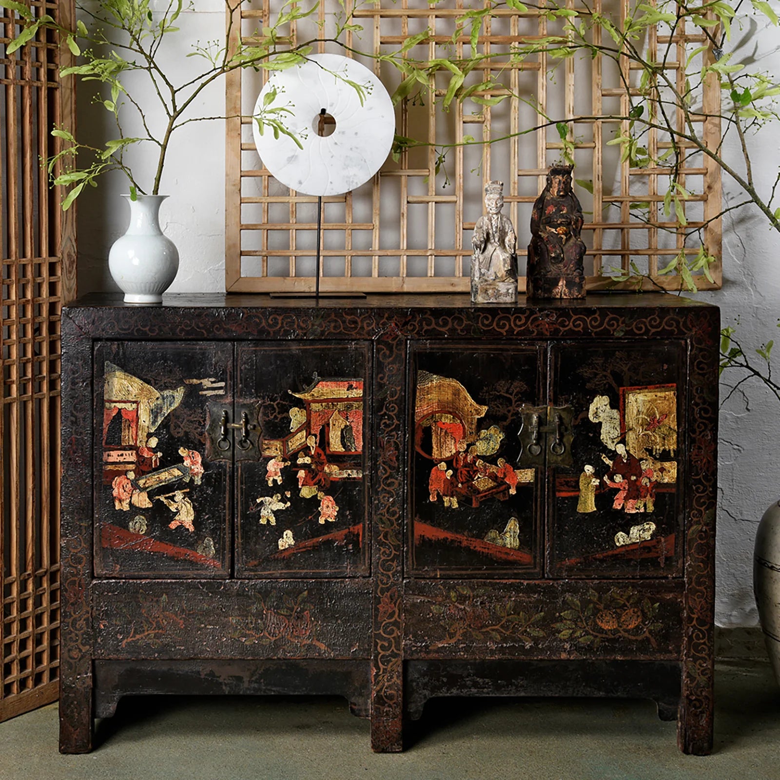 A painted Chinese sideboard paired with various accessories and plants