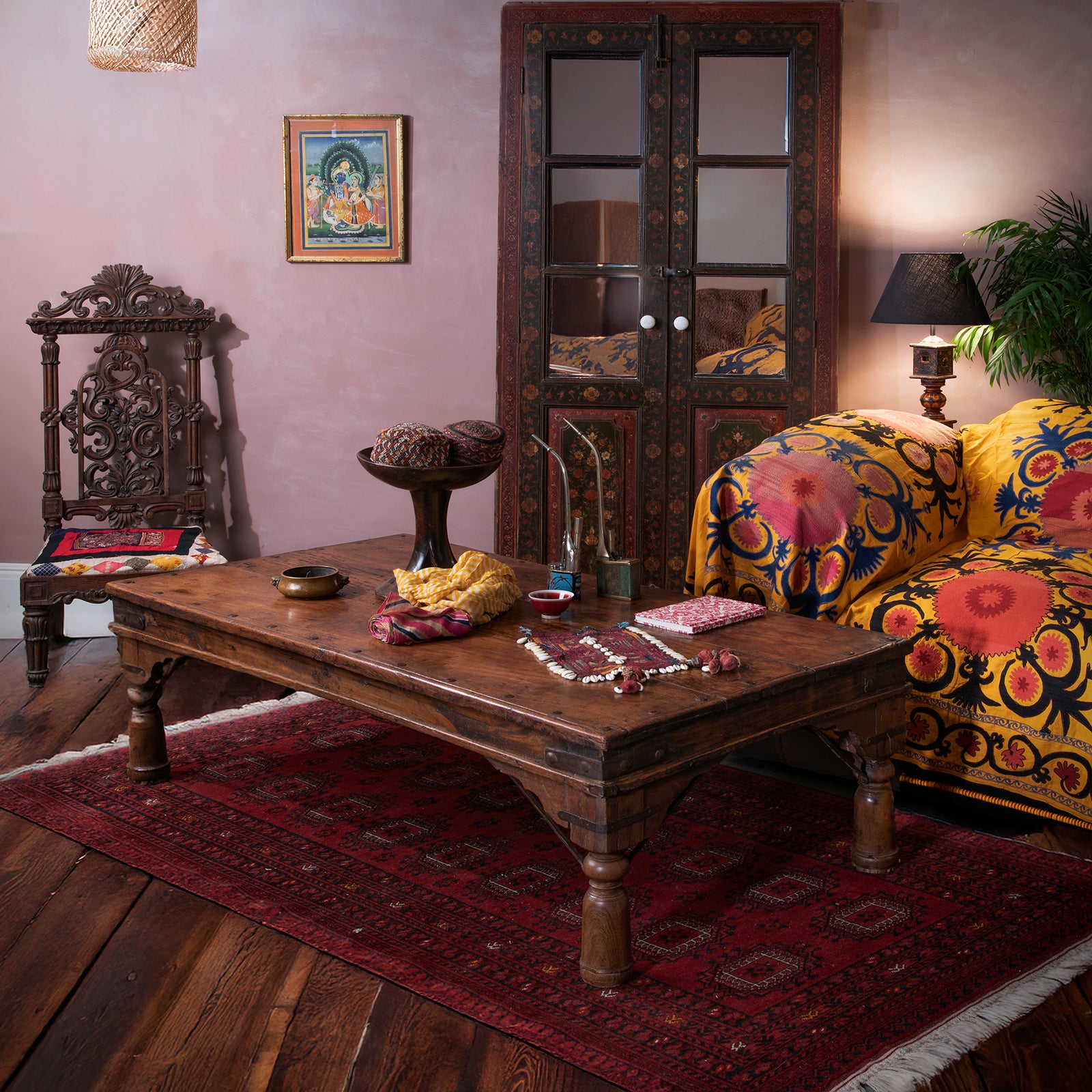 Rich and rustic Indian interior living room with plush suzani fabrics and an antique takhat table
