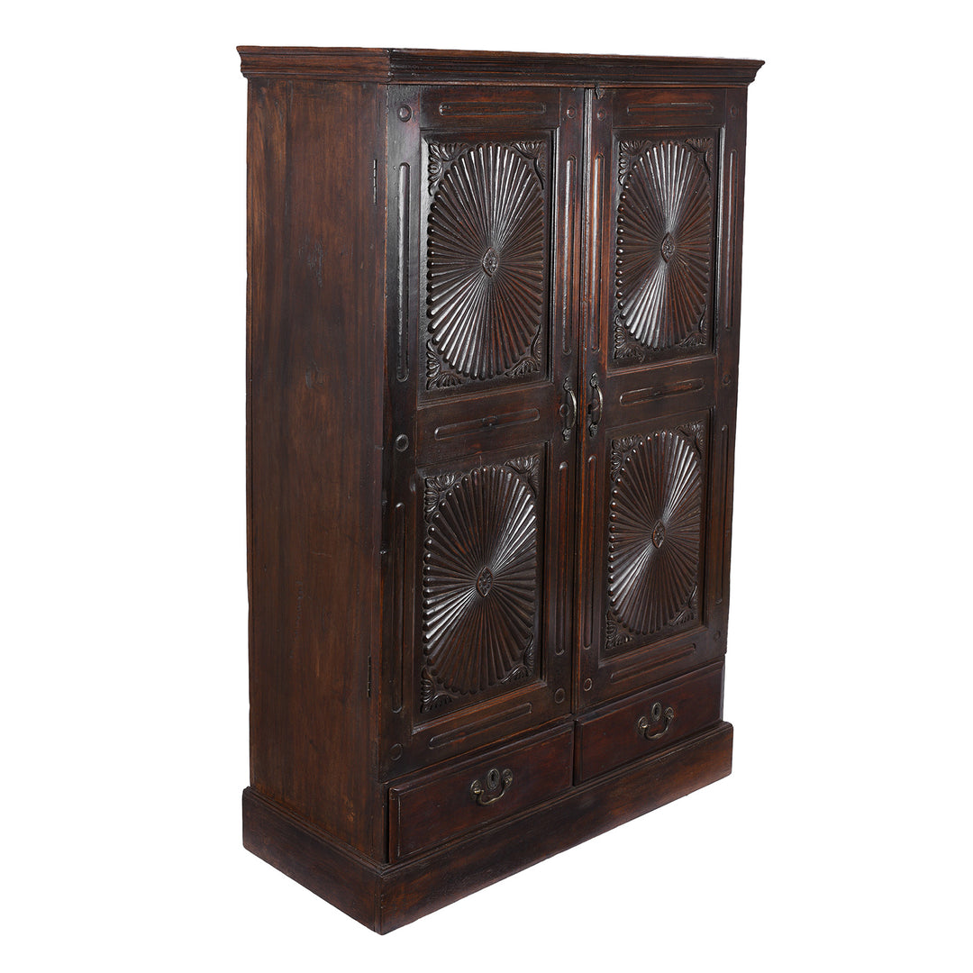 Angled View Of Antique Indian Teak Almirah Cabinet With Hand Carved Sunburst Panels And Rich Aged Patina