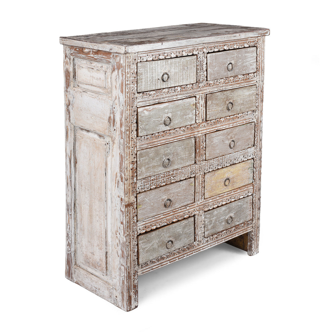 Angled VIew Of Reclaimed Teak Chest Of Drawers With Ten Drawers And Hand Carved Detailing In Distressed White Finish | Indigo Antiques