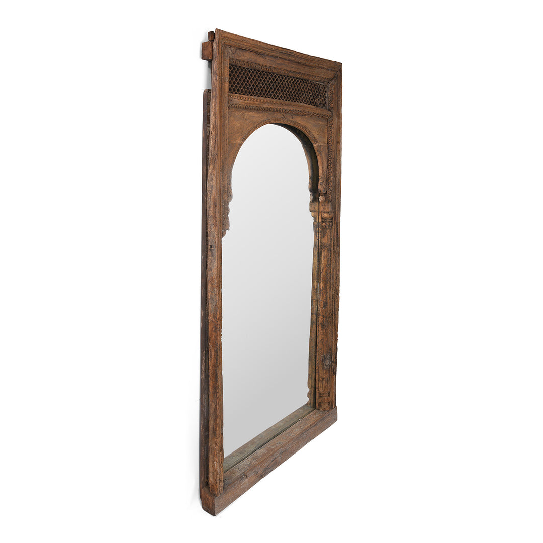 Angled VIew Of Antique Indian Mirror Made From A 19th-Century Hand-Carved Teak Window Frame With Mughal Arch And Jali Panel From Madhya Pradesh.