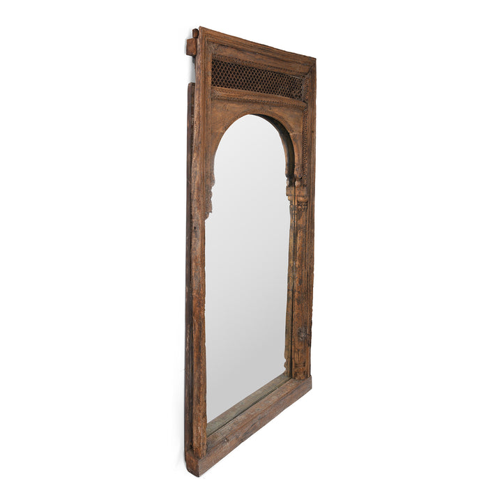 Angled VIew Of Antique Indian Mirror Made From A 19th-Century Hand-Carved Teak Window Frame With Mughal Arch And Jali Panel From Madhya Pradesh.