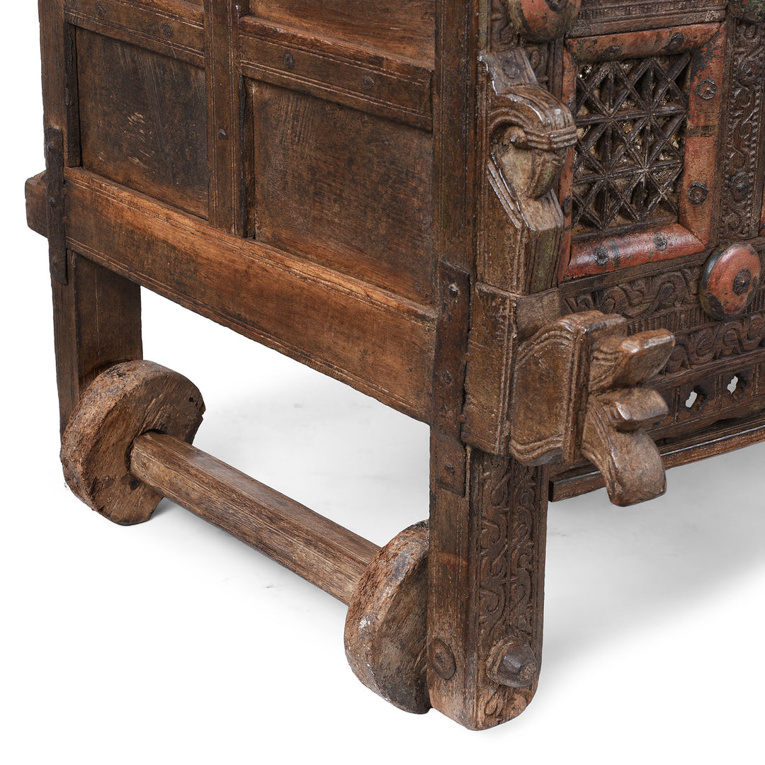 Wheels Detail From Antique 19th-century Indian dowry chest from Gujarat with intricate animal carvings, geometric patterns, and hidden compartments, set on wheels.