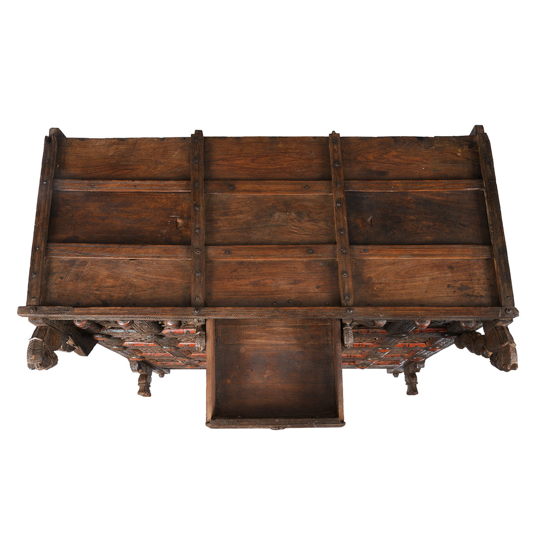 Top DOwn View Of Antique 19th-century Indian dowry chest from Gujarat with intricate animal carvings, geometric patterns, and hidden compartments, set on wheels.