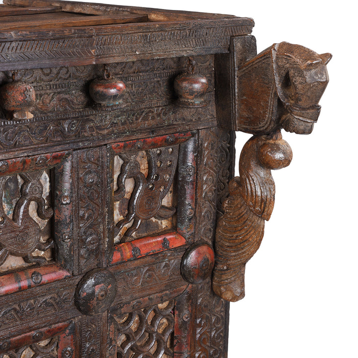 Horse Carving Detail From Antique 19th-century Indian dowry chest from Gujarat with intricate animal carvings, geometric patterns, and hidden compartments, set on wheels.
