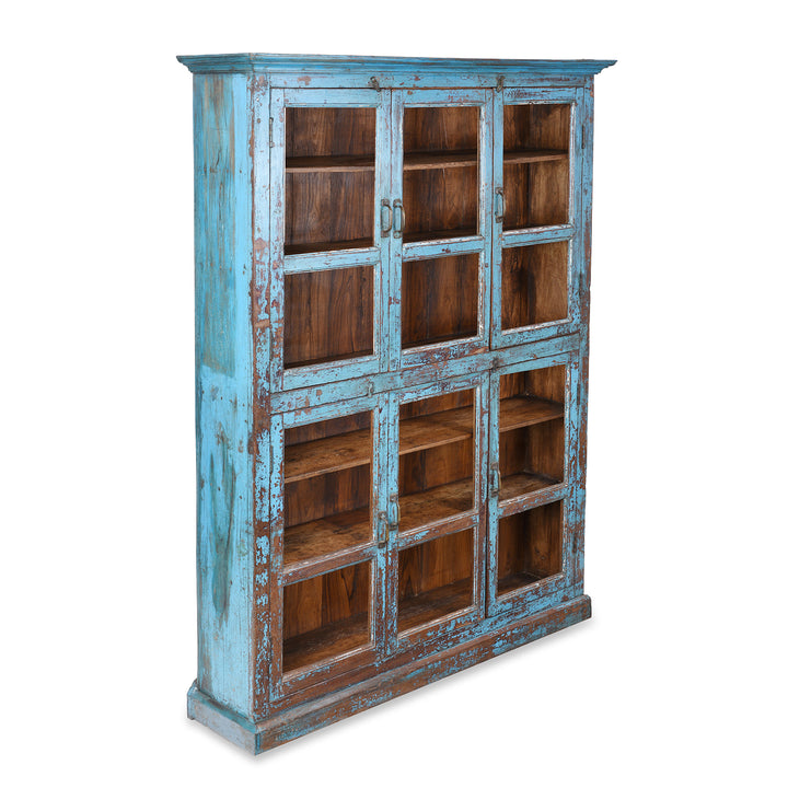 Angled View Of Antique Indian Teak Book Cabinet With Distressed Blue Frame, Warm Teak Interior, Five Shelves, And Sliding Central Panels