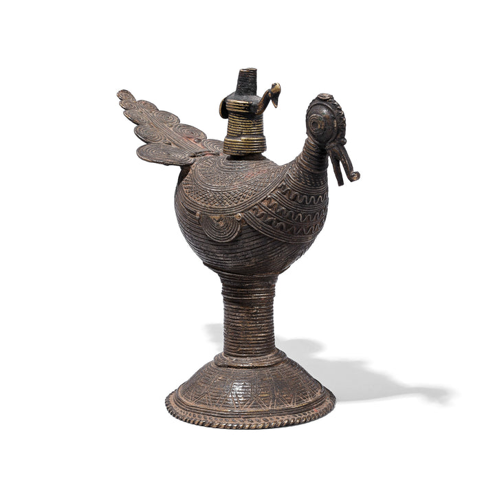 Angled VIew Of Brass Dhokra Peacock Oil Lamp From Orissa With Geometric Detailing And Aged Patina Circa 1920