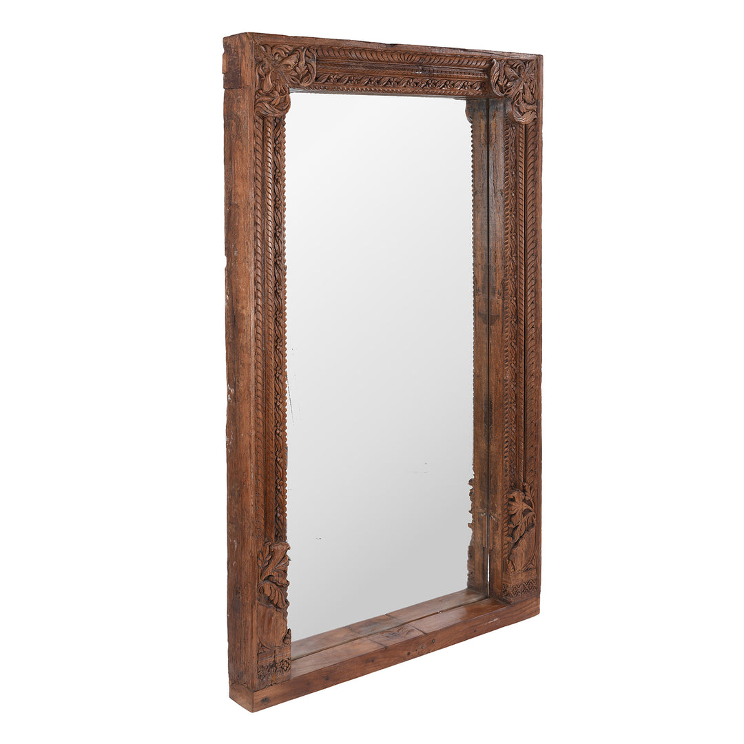 Angled VIew Of 19th-Century South Indian Teak Mirror With Intricate Botanical Carvings And Temple-Inspired Details.