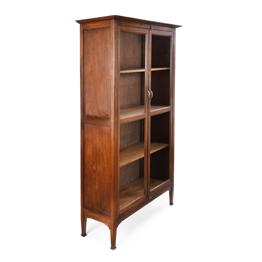 Angled View Of Antique Anglo-Indian teak book cabinet from Gujarat, circa 1910, with glazed doors and three interior shelves