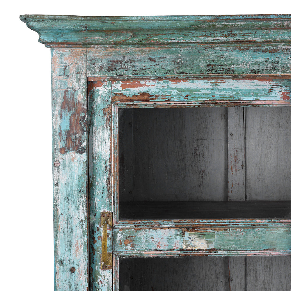 Corner Detail SHowing Faded Paintwork On Green painted Indian teak glazed cabinet circa 1920 with four sliding glass panels, three fixed shelves and distressed original paint | Indigo Antiques