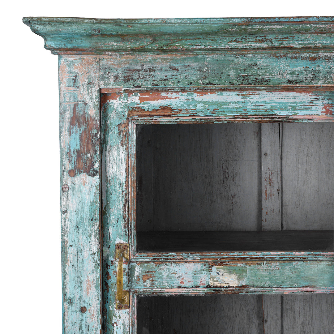 Corner Detail SHowing Faded Paintwork On Green painted Indian teak glazed cabinet circa 1920 with four sliding glass panels, three fixed shelves and distressed original paint | Indigo Antiques