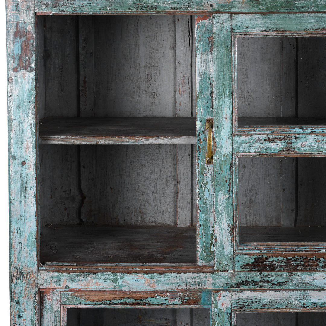 Open Panel View Of Green painted Indian teak glazed cabinet circa 1920 with four sliding glass panels, three fixed shelves and distressed original paint | Indigo Antiques