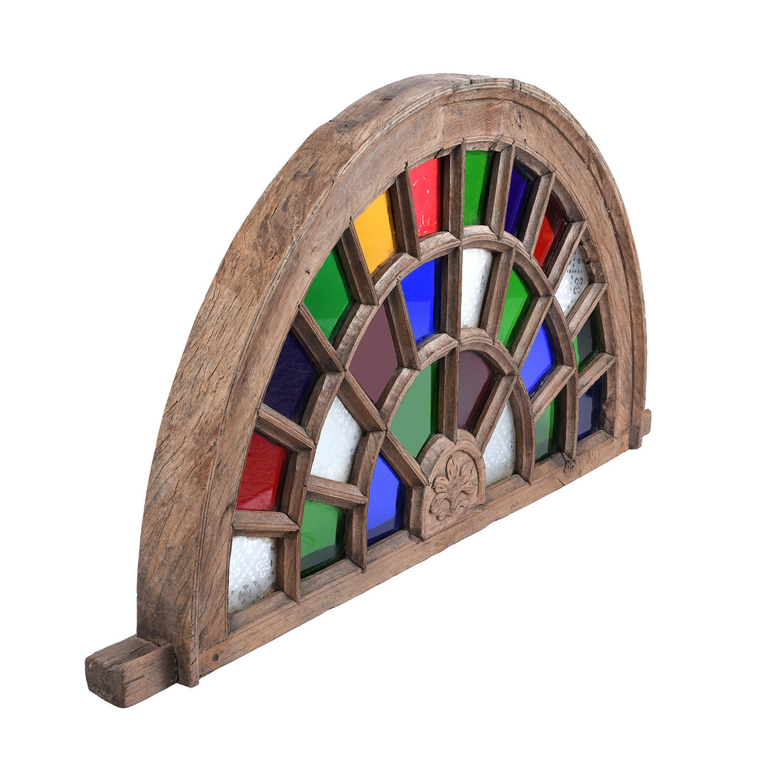 Angled View Of Early 20th Century Indian Stained Glass Fanlight Window With Carved Wooden Frame And Multicoloured Glass Panels | Indigo Antiques