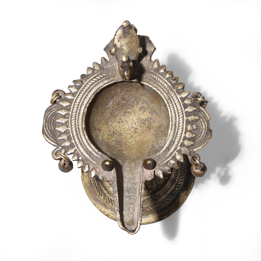 Top Down View Of Circa 1920 Dhokra Brass Oil Lamp From Chhattisgarh With Peacock Finial And Suspended Bell Ornaments Cast Using Lost Wax Technique