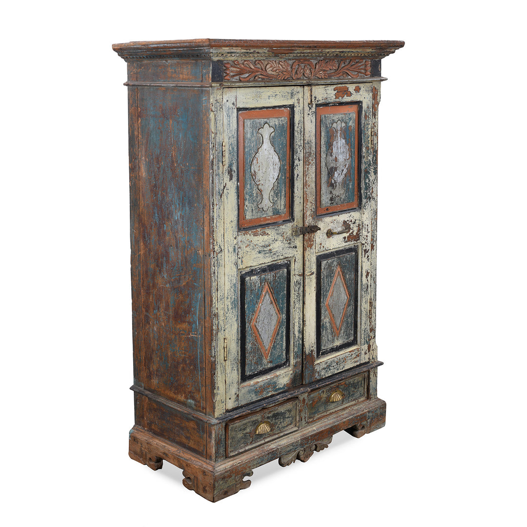 Angled View Of Painted 19th Century Indian Almirah Cabinet With Distressed Cream Blue And Terracotta Finish Carved Frieze Three Shelves And Two Drawers | Indigo Antiques