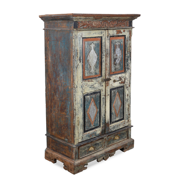 Angled View Of Painted 19th Century Indian Almirah Cabinet With Distressed Cream Blue And Terracotta Finish Carved Frieze Three Shelves And Two Drawers | Indigo Antiques