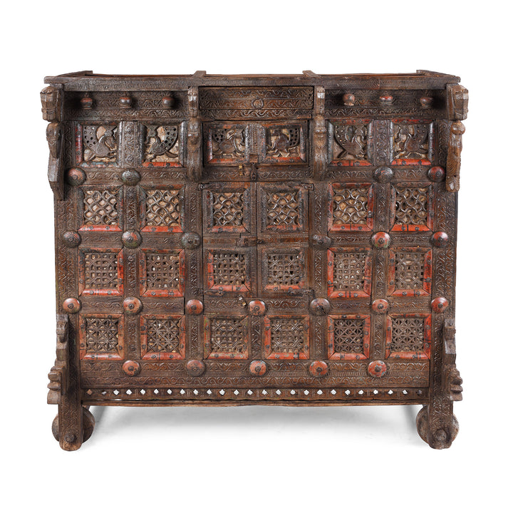 Antique 19th-century Indian dowry chest from Gujarat with intricate animal carvings, geometric patterns, and hidden compartments, set on wheels.