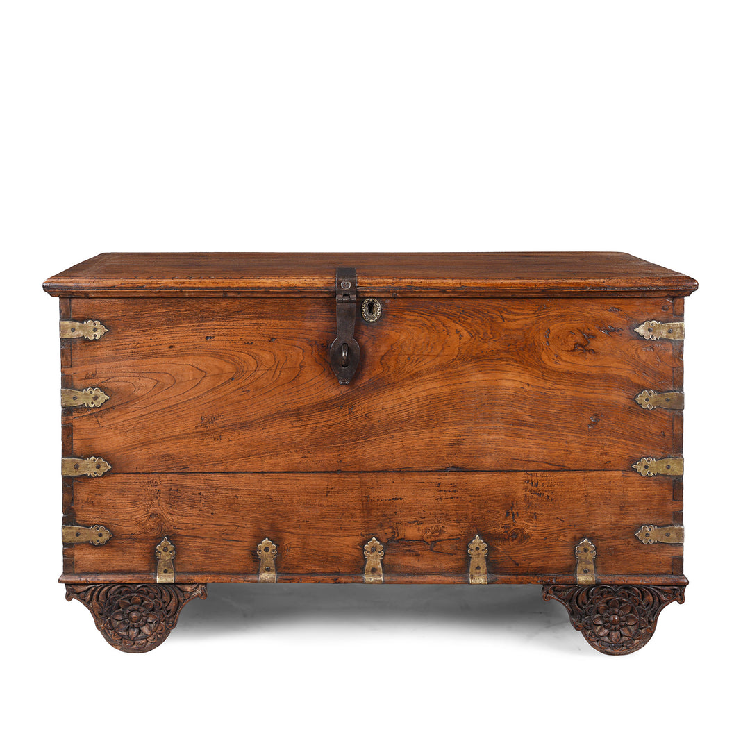 Antique mid-19th century teak chest from Gujarat with hidden wheels, carved floral feet, and original iron fittings.