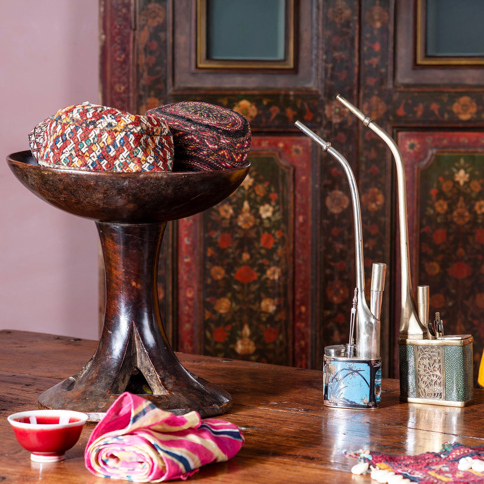 Oriental antiques on a table with a decorative Indian antique painted door in the background