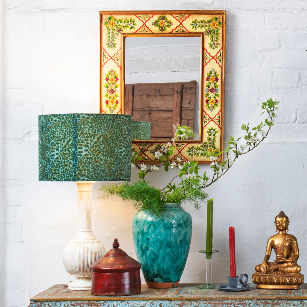 A bold & bohemian interior living room decorated with Indian Rajasthani painting and decorative green tones