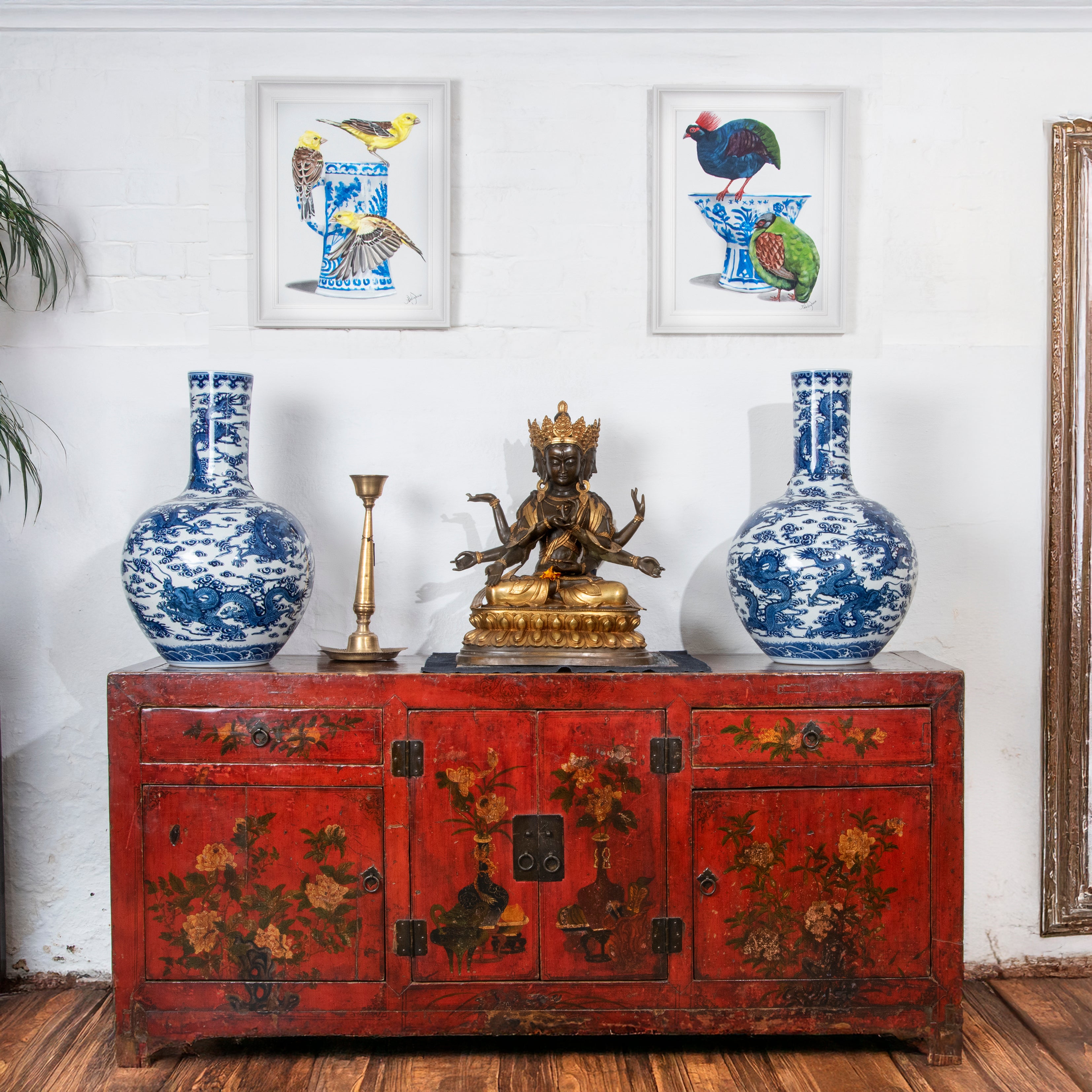 Red cabinet with blue vases and a gold statue