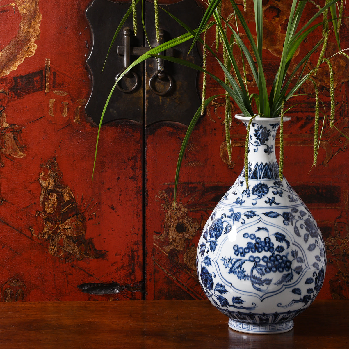 Blue & White Porcelain Pomegranate Yuhuchunping Vase infront of a Chinese red lacquer wedding cabinet | Indigo Antiques