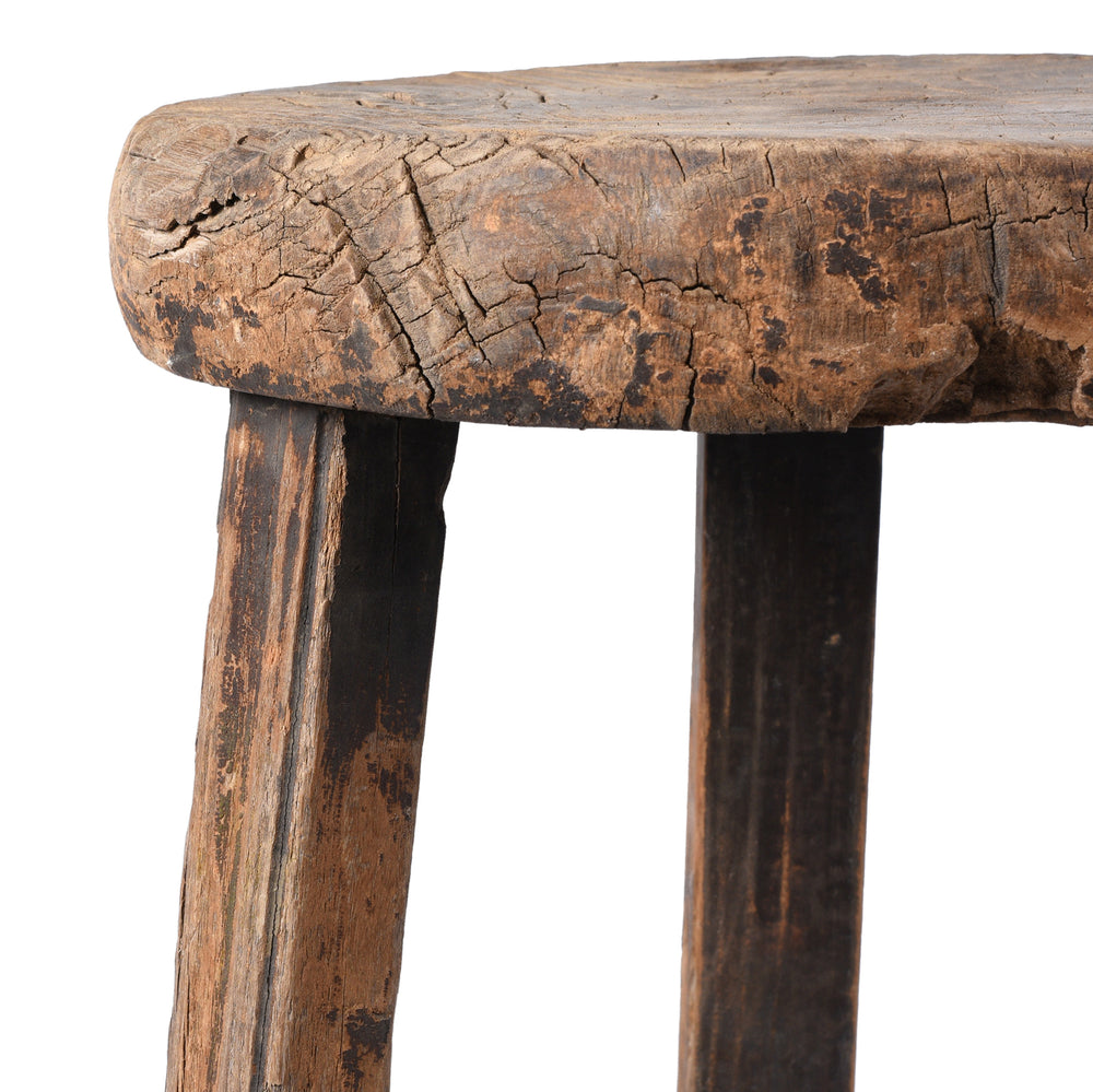 Close-up of a rustic wooden stool with a white background
