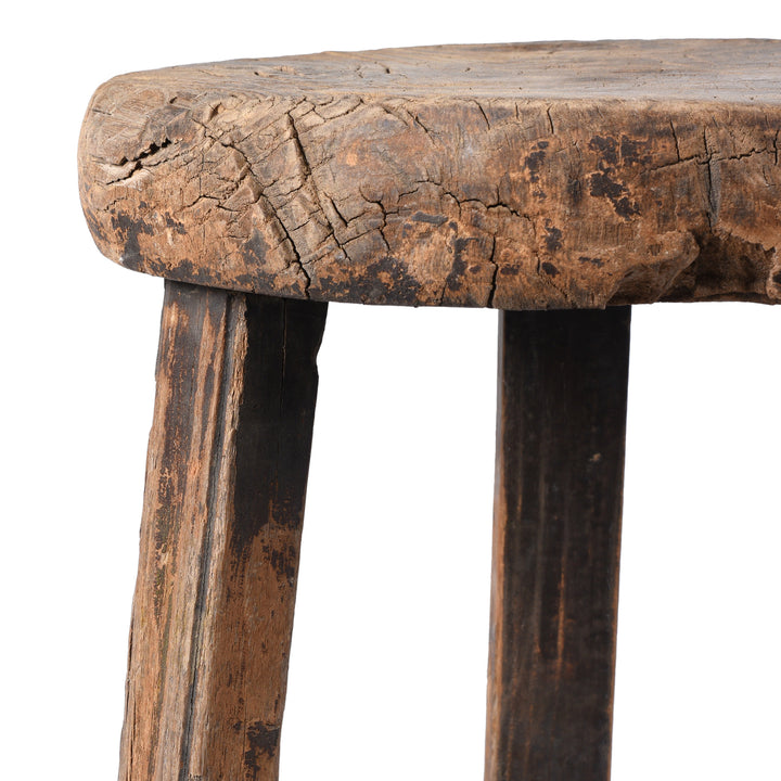 Close-up of a rustic wooden stool with a white background
