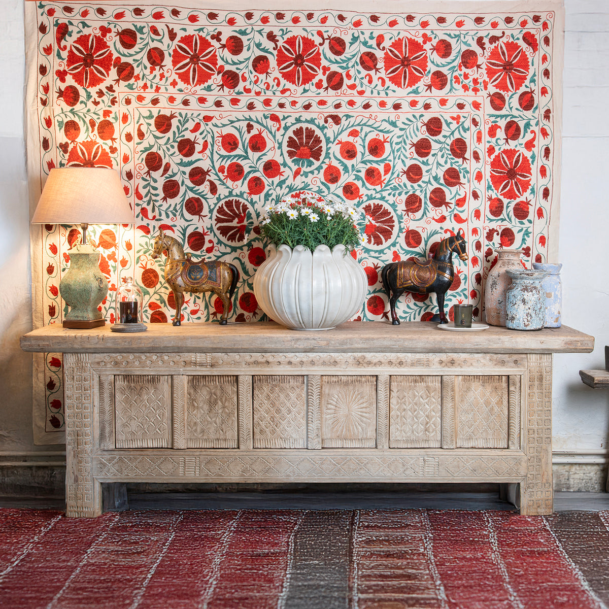 Antique bold decorated interior with a Chinese sideboard & hand stitched suzani wall hanging. 
