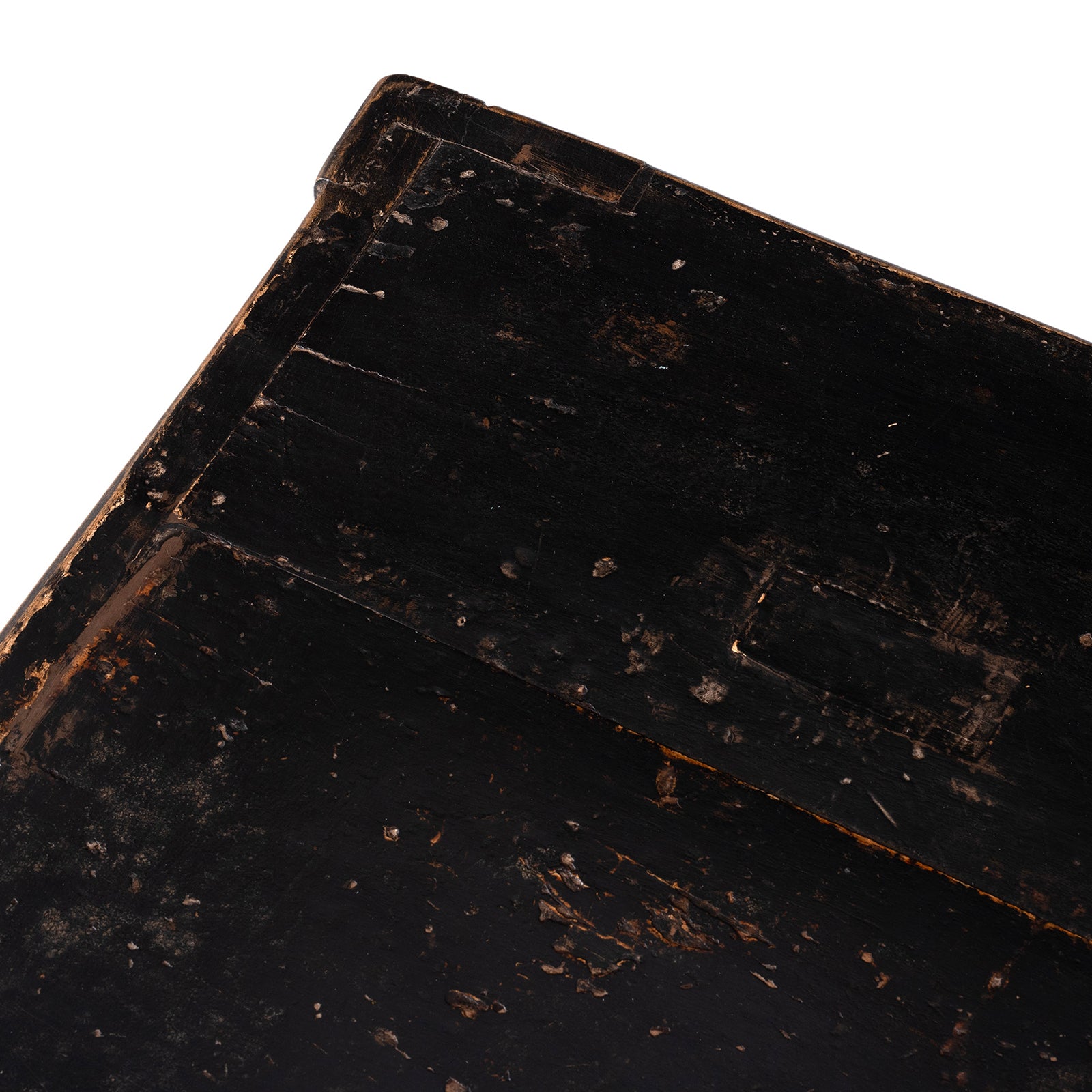 Close-up of a worn black painted surface with visible scuffs and aging.