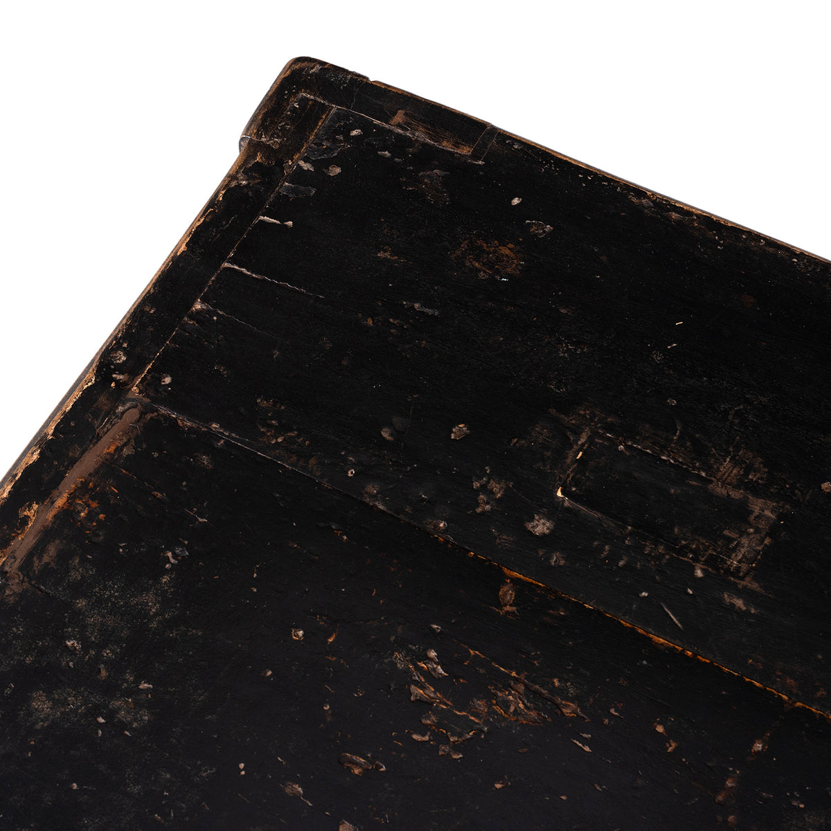 Close-up of a worn black painted surface with visible scuffs and aging.