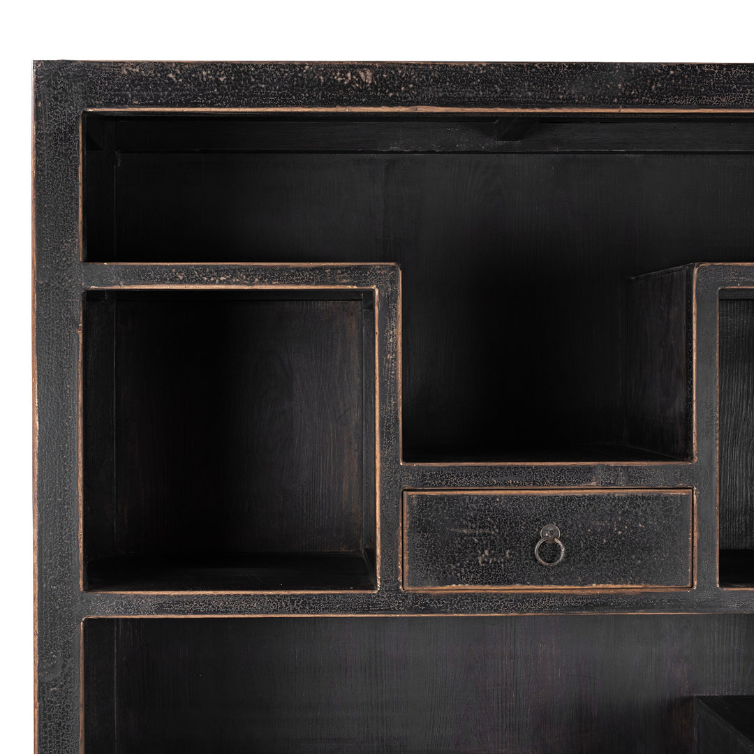 Corner Detail From Tall Black Distressed Pine Shelf Unit With Geometric Open Compartments And Drawers