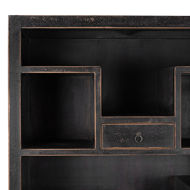 Corner Detail From Tall Black Distressed Pine Shelf Unit With Geometric Open Compartments And Drawers