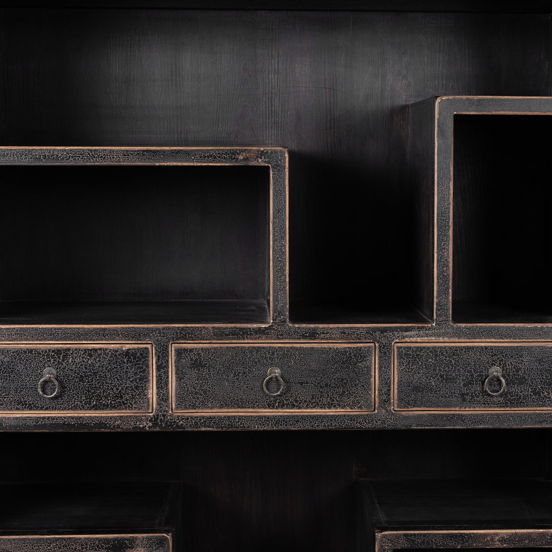 Drawer And Storage Area Detail From Tall Black Distressed Pine Shelf Unit With Geometric Open Compartments And Drawers