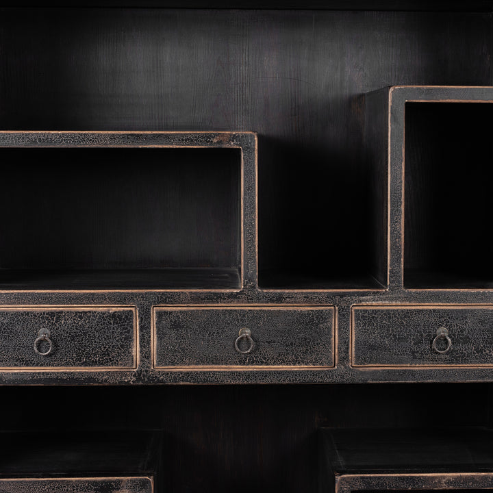 Drawer And Storage Area Detail From Tall Black Distressed Pine Shelf Unit With Geometric Open Compartments And Drawers
