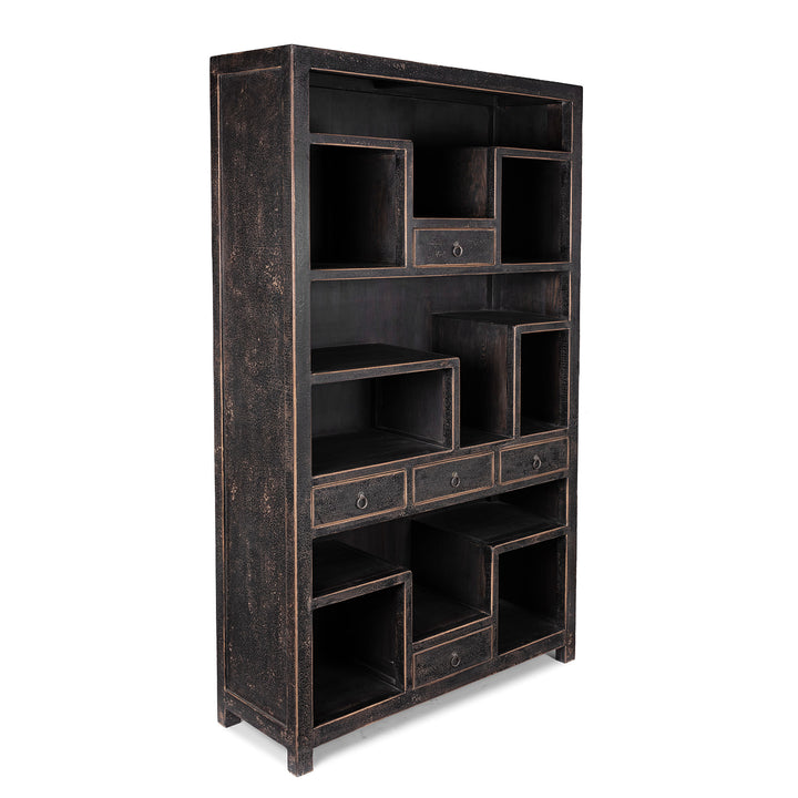 Angled View Of Tall Black Distressed Pine Shelf Unit With Geometric Open Compartments And Drawers