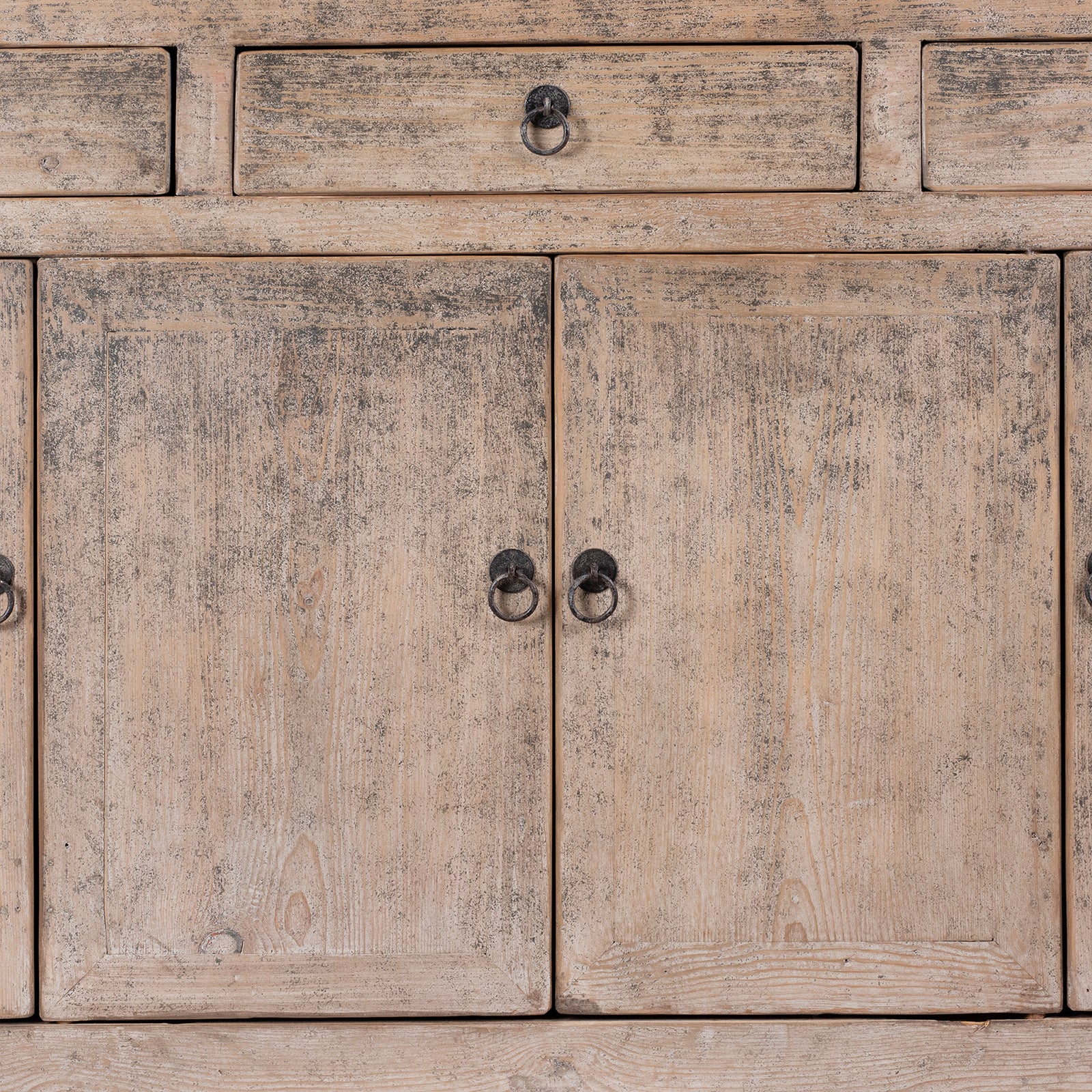 Close-up of a wooden cabinet with distressed finish and metal handles.