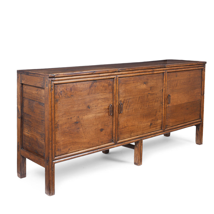Angled View Of 19th Century Chinese Three Door Wooden Sideboard With Panelled Doors And Internal Shelving | Indigo Antiques