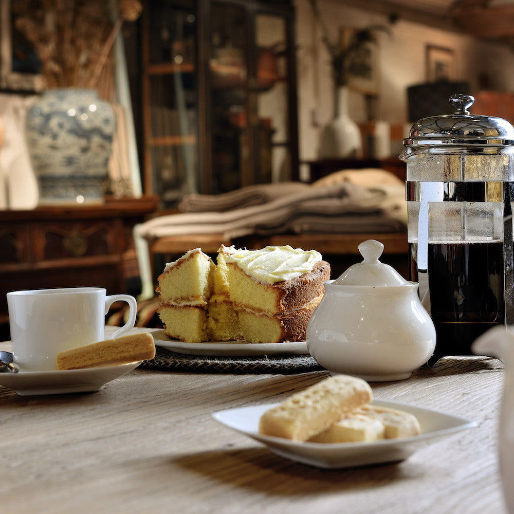 Cake and tea pot in a cosy room