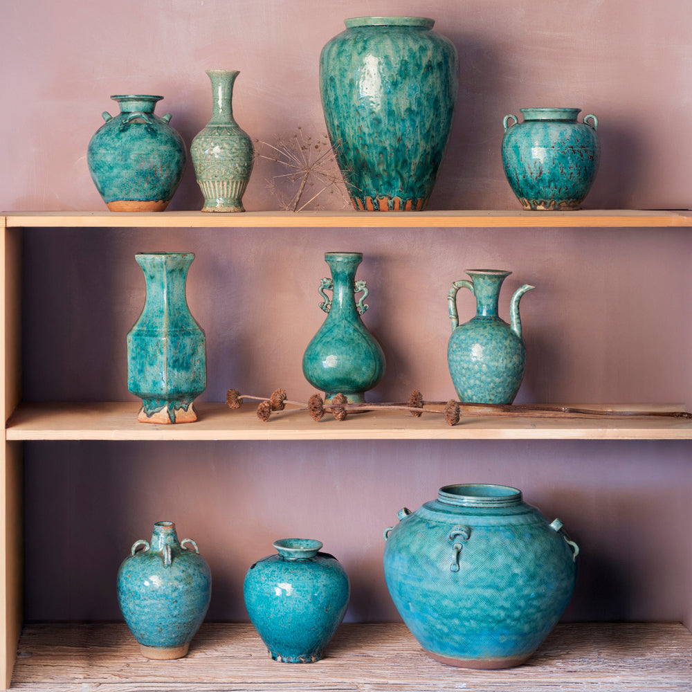 Vibrant copper green flambe glazed Chinese porcelain vases from Jingdezhen on a bleached shelf