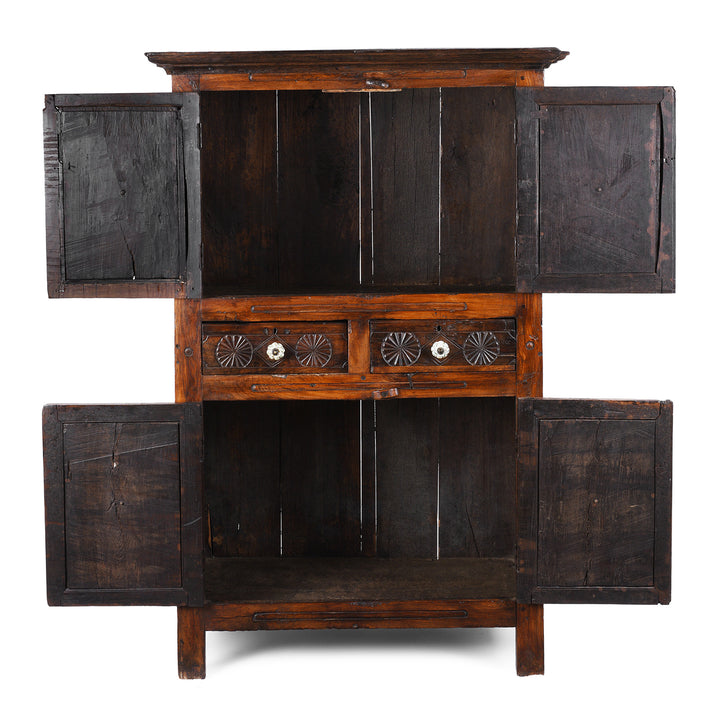 Interior View Of Indian Teak Almirah Cabinet With Hand-Carved Sunburst Panels, Two Drawers And White Ceramic Handles