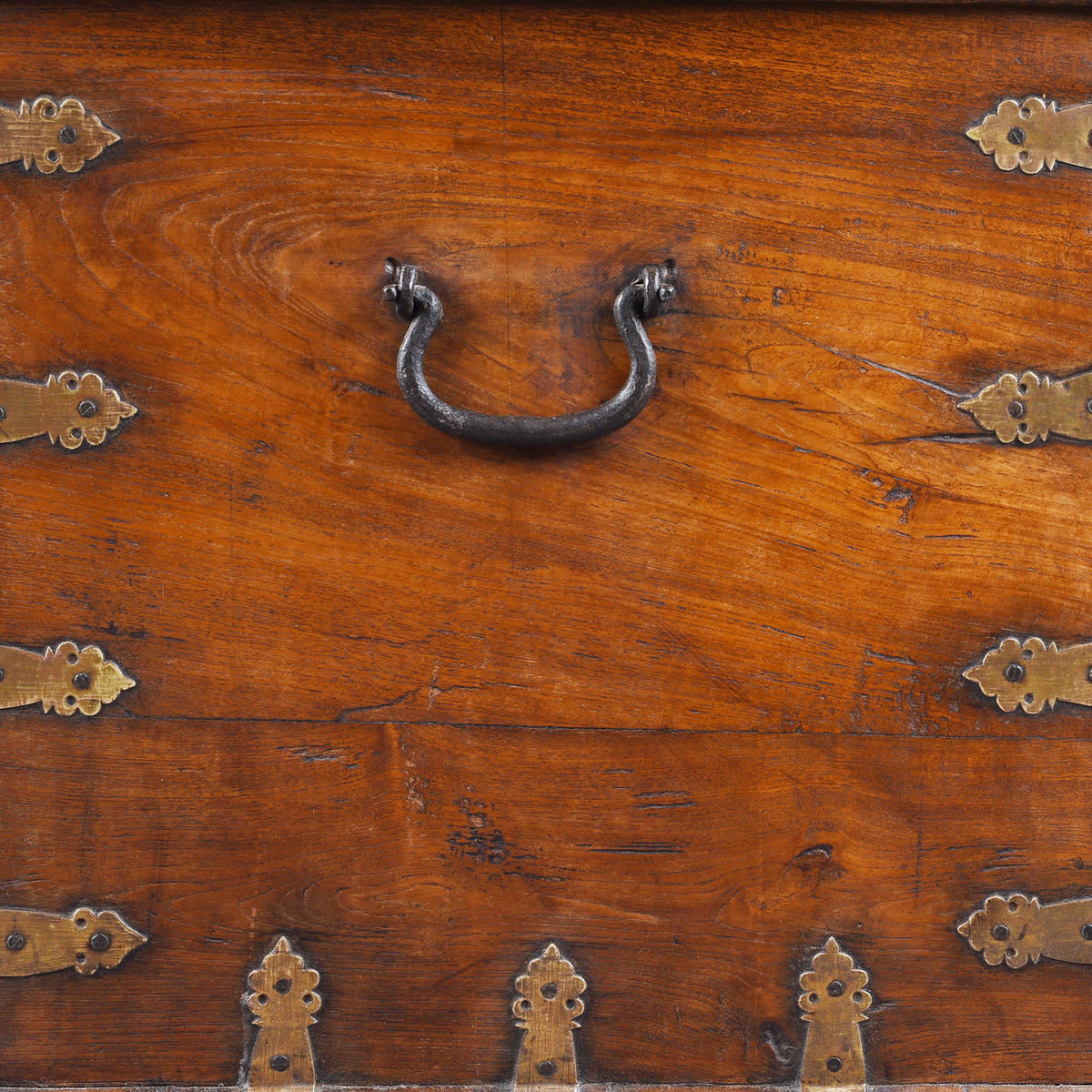 Handle Detail From Antique mid-19th century teak chest from Gujarat with hidden wheels, carved floral feet, and original iron fittings.