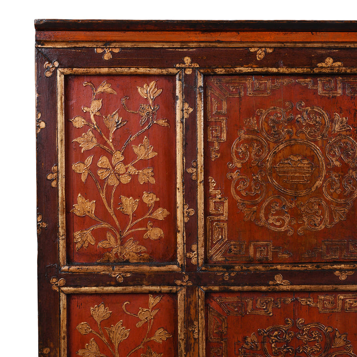 Detail of prunus design & Precious Medicine kyungbur raised red & gold gesso work on an antique Tibetan altar cabinet dating to the 19th century