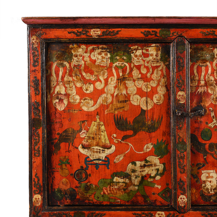 Torma offering in an upturned skull cup  & intestines held in the mouths of skulls and severed heads on an Antique Painted Tibetan Mahakala Torgam Cabinet Decorated with Skulls and for holding Torma - 18thC