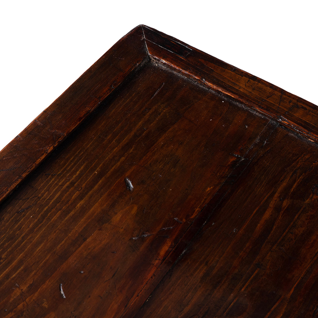 Close-up of a dark wooden surface with visible grain and texture.