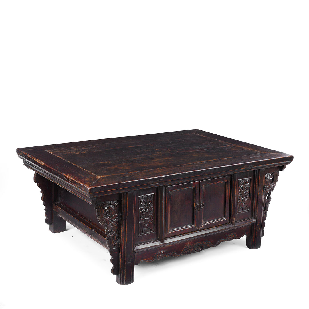 Angled View Of Mid 19th Century Chinese Shanxi Black Lacquer Elm Kang Table With Floral Carvings And Cupboard Doors