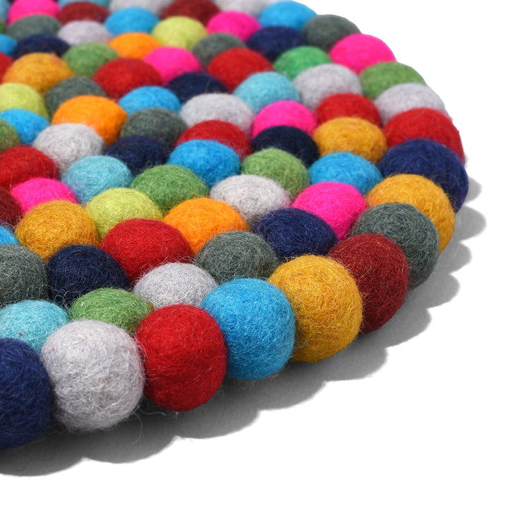 Angled View Of Handmade 28cm multi-coloured felt ball singing bowl cushion from Nepal, crafted from individually hand-felted wool balls to provide a stable and protective base for Tibetan singing bowls