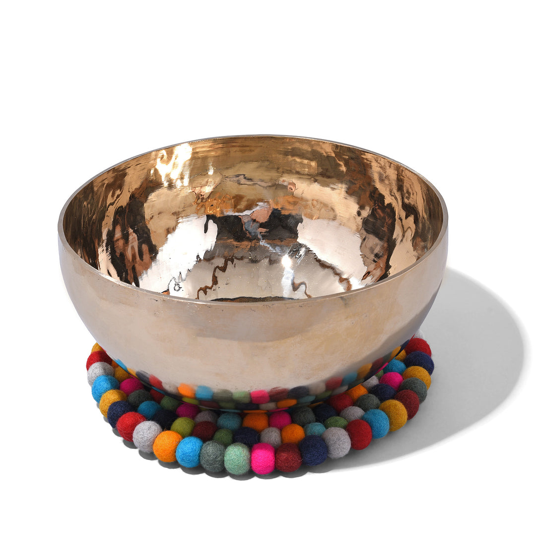 View Of Handmade 28cm multi-coloured felt ball singing bowl cushion from Nepal, crafted from individually hand-felted wool balls to provide a stable and protective base for Tibetan singing bowls with bowl on