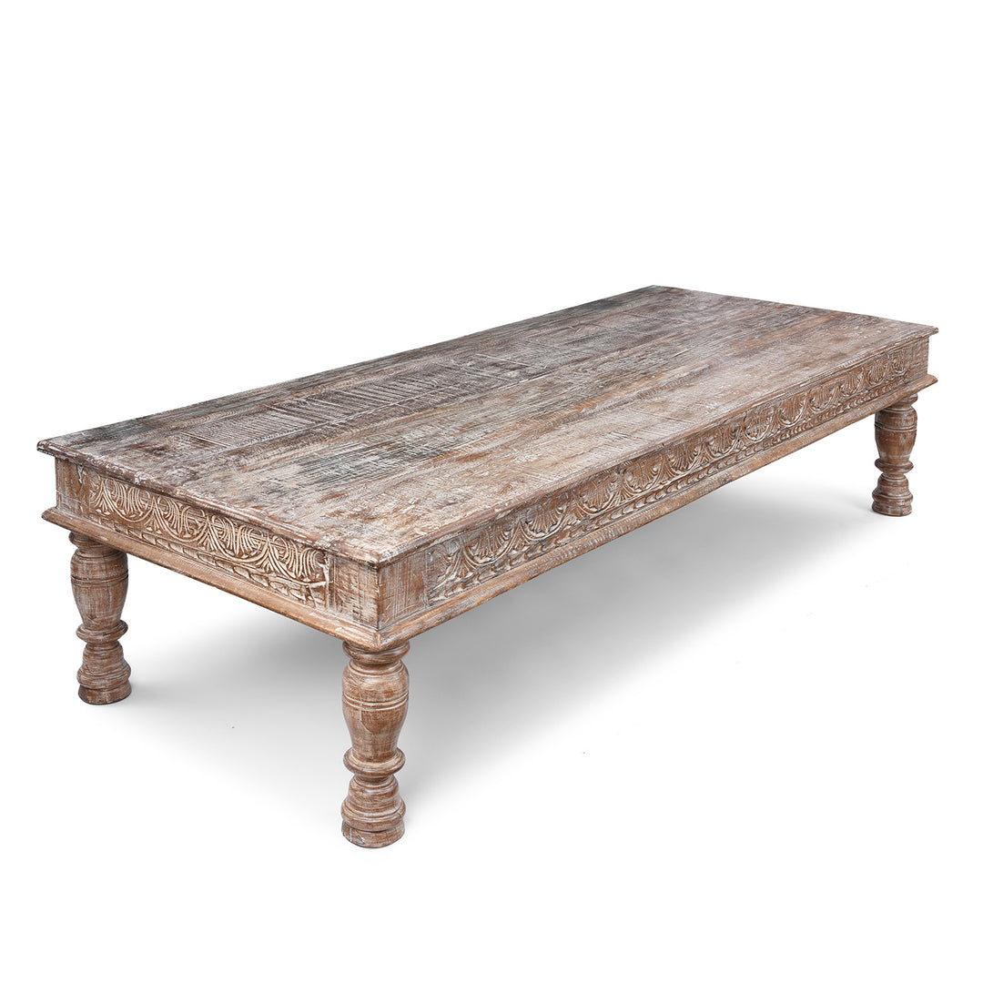 Angled VIew Of Reclaimed Teak Takhat Coffee Table Made From Antique Indian Architectural Wood With Distressed Finish And Carved Apron