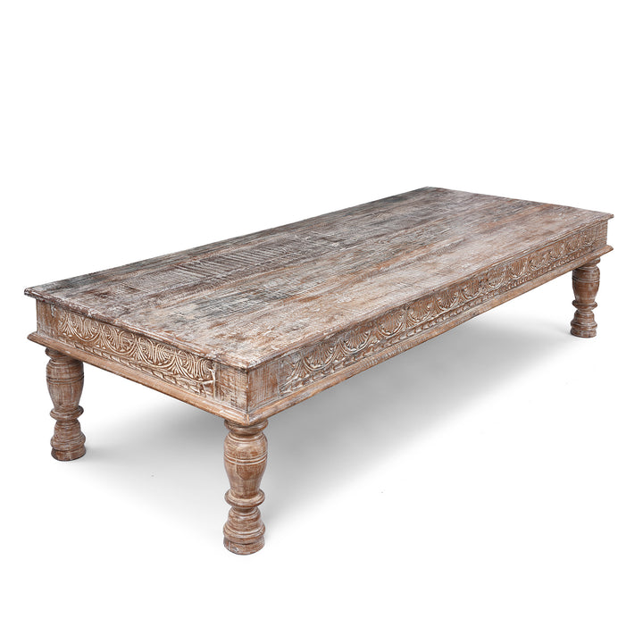 Angled VIew Of Reclaimed Teak Takhat Coffee Table Made From Antique Indian Architectural Wood With Distressed Finish And Carved Apron
